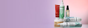 A range of Ouidad's best selling culy hair care products laid out on a gray background