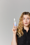 Model holding bottle of Unbreakable Bonds Mixing Drops 