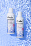 Ouidad Unbreakable Bonds Bond Building Shampoo and Conditioner bottles on blue water background